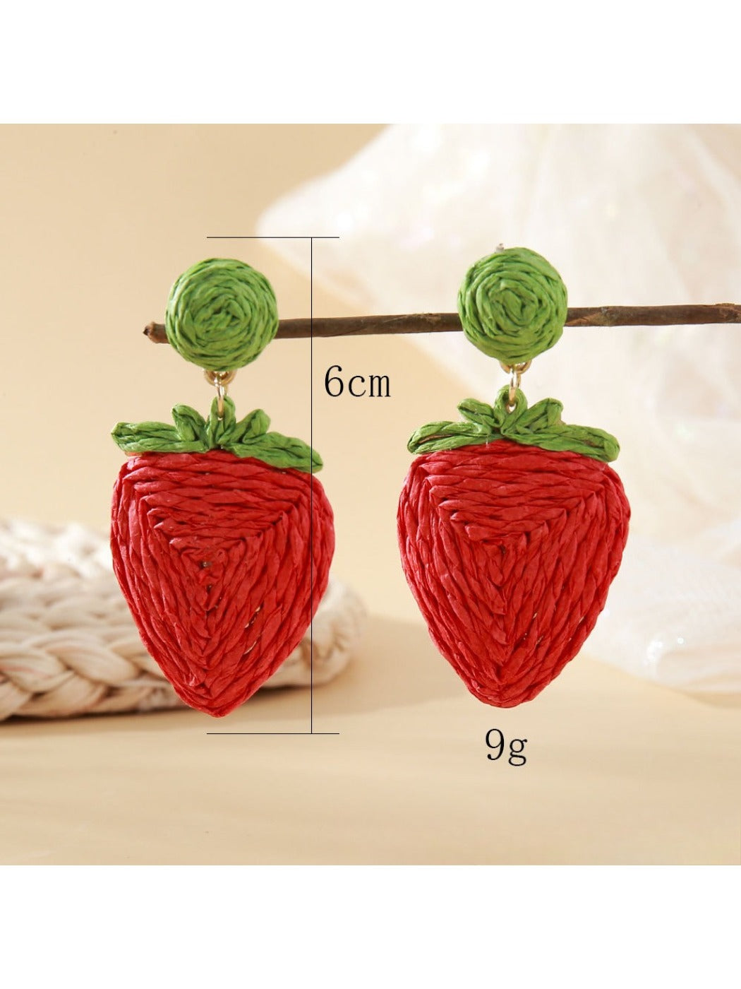 Side view of raffia woven strawberry earrings showing texture and weave