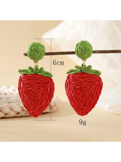 Side view of raffia woven strawberry earrings showing texture and weave