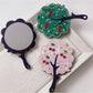 Side view of Mirroray handheld mirror highlighting the slim tree-shaped frame