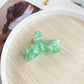 Beau bow shaped hair claw clip resting on fabric background