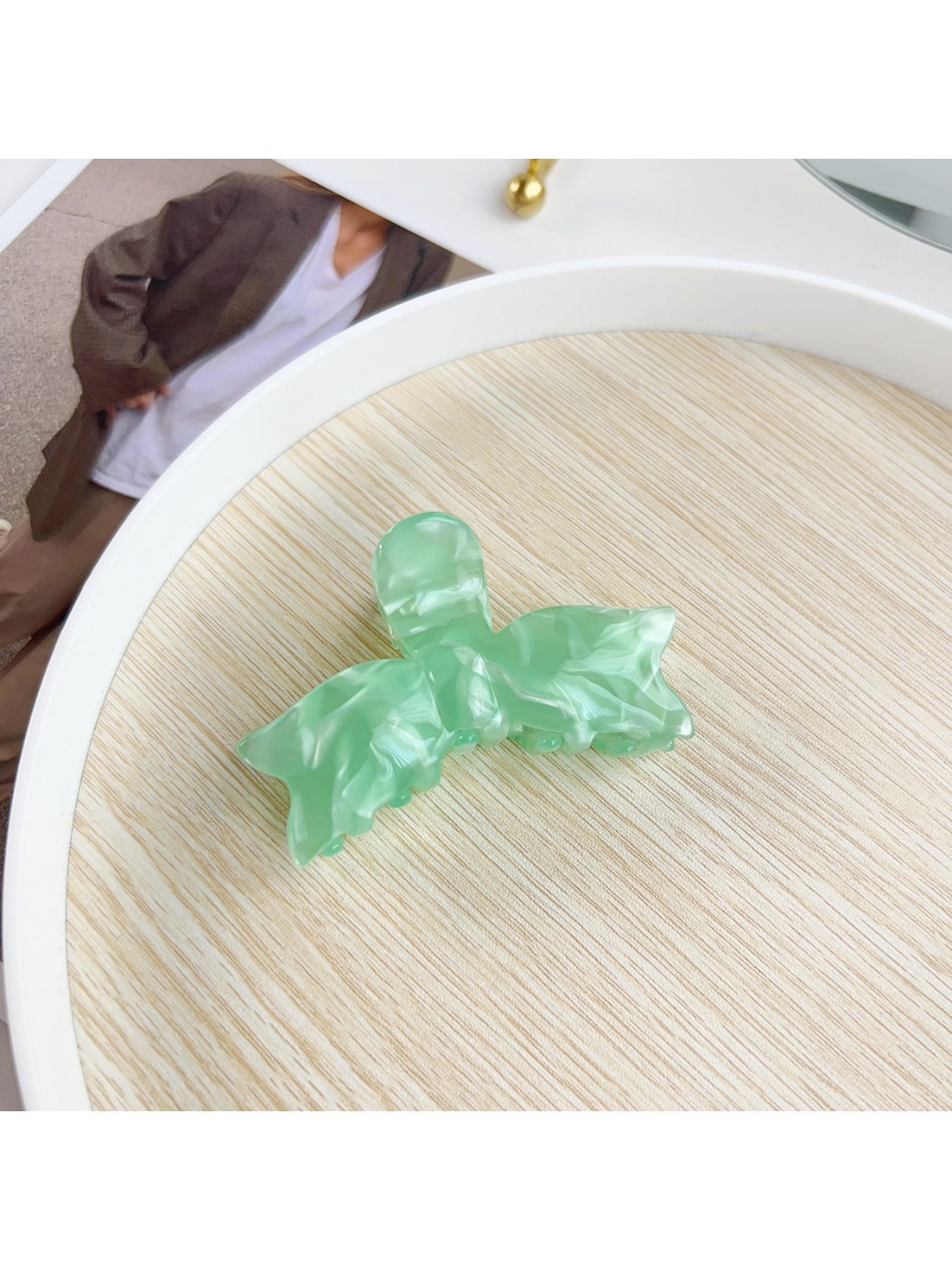 Beau bow shaped hair claw clip resting on fabric background