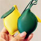 Hand holding the lemon-shaped keychain showing its size and details