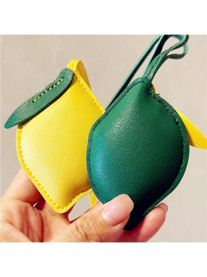 Hand holding the lemon-shaped keychain showing its size and details