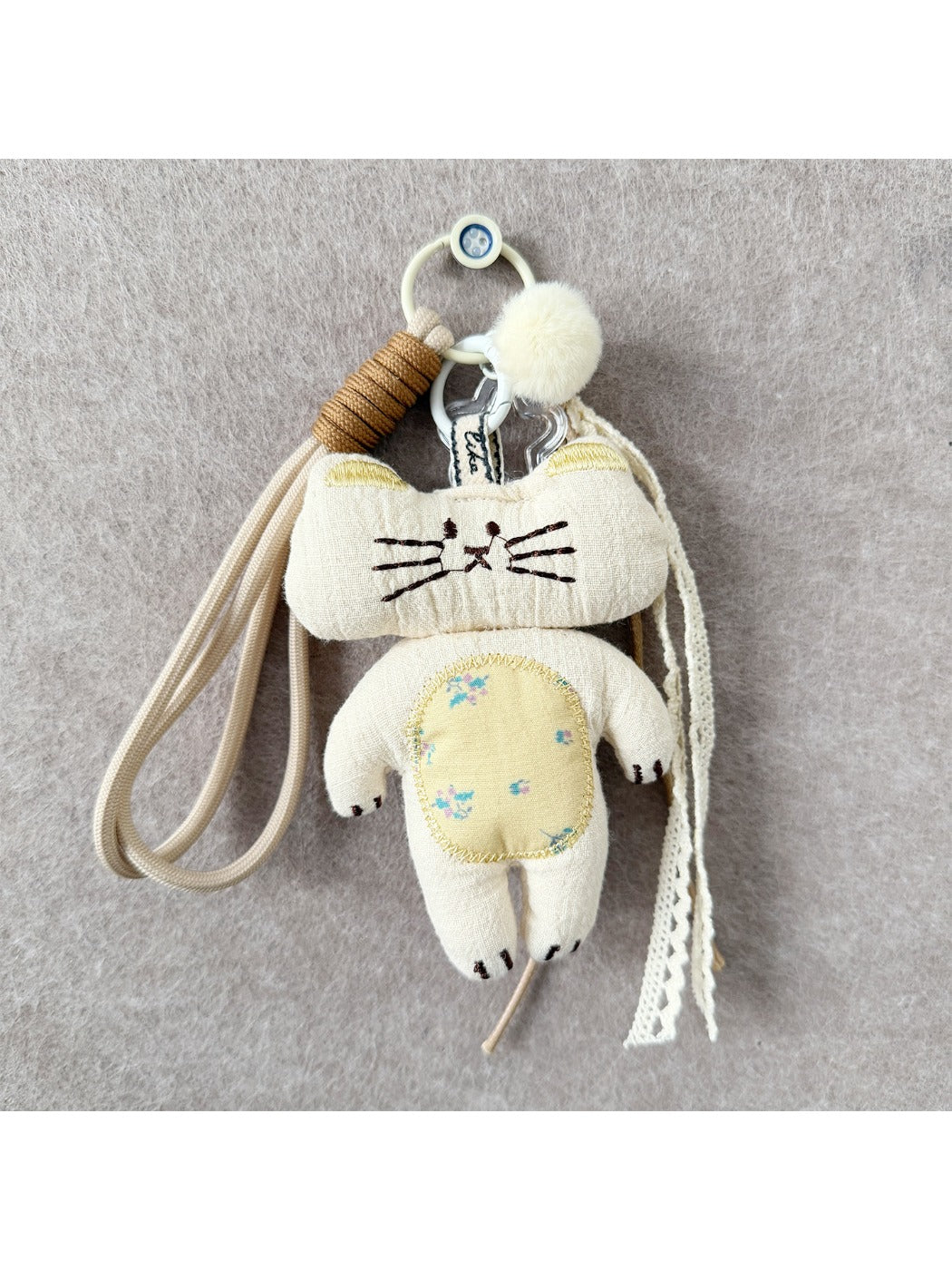 Fabric rabbit and cat keychains hanging from a metal ring, showing front and side views