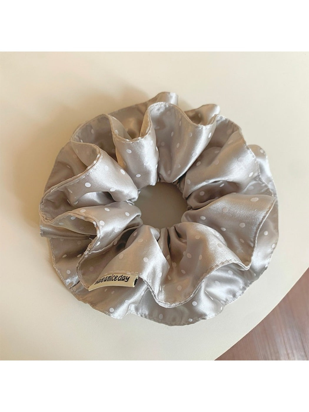 Gifty chic satin scrunchie with black and white polka dot pattern on a white background