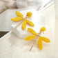 Side view of raffia dragonfly earring showing natural fiber texture