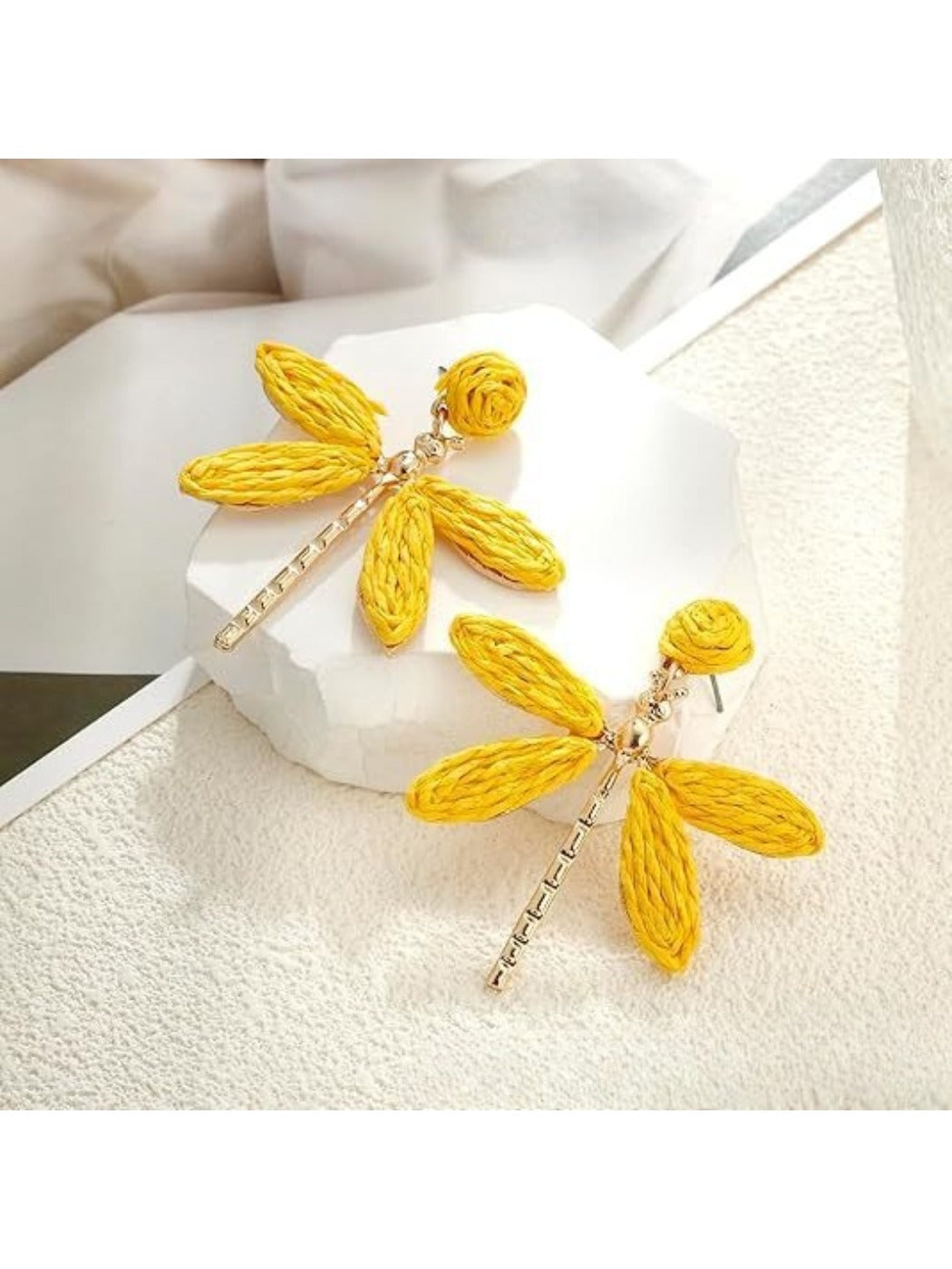 Side view of raffia dragonfly earring showing natural fiber texture