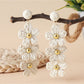 Detailed view of raffia fibers woven into flower shape on drop earrings