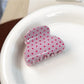 Beau sweet pink polka dot hair claw clip angled to show glossy finish