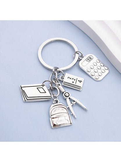 Close-up of the book-shaped alloy backpack keychain showing detailed texture