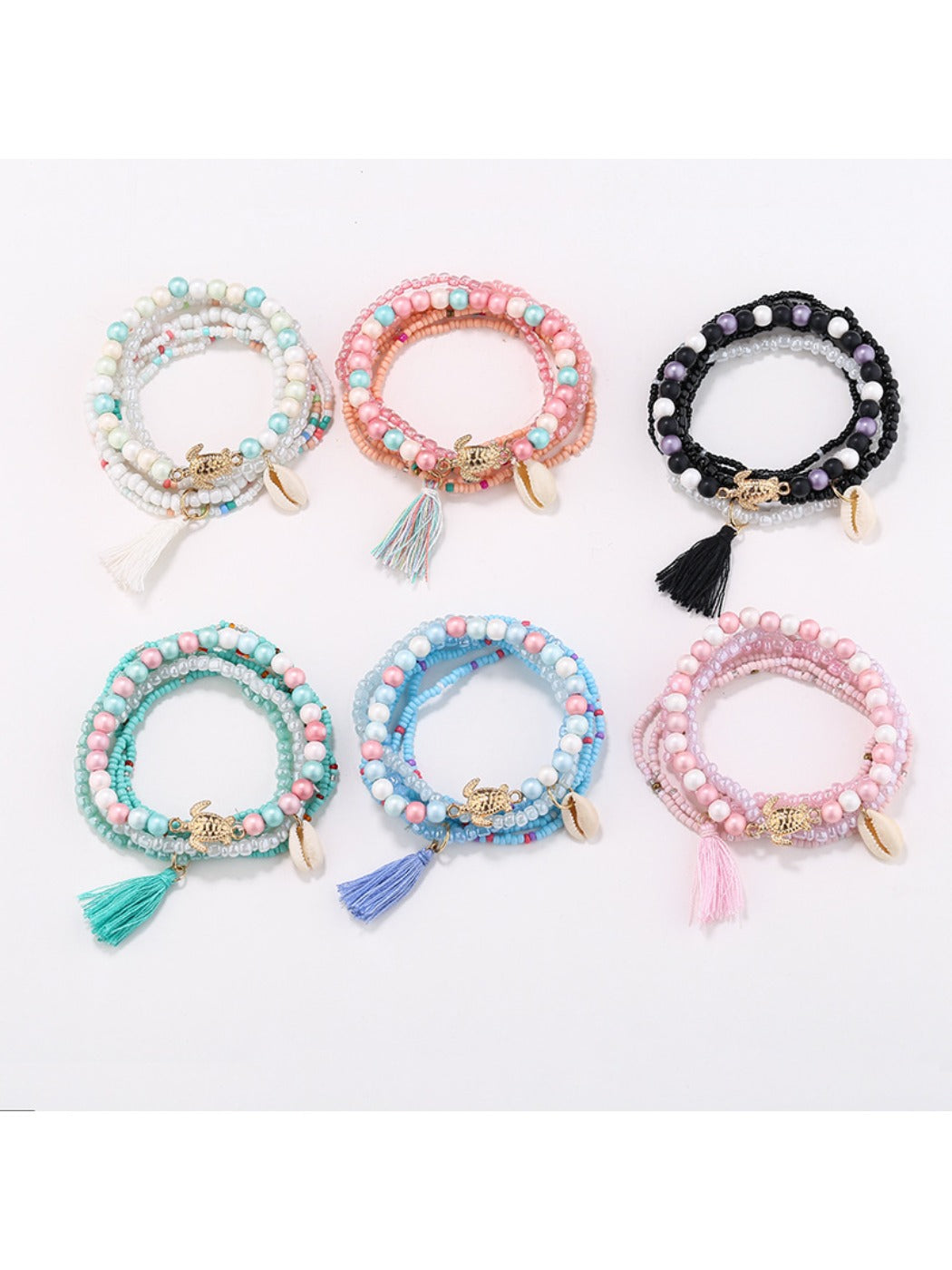 Close-up of Lovra stackable tassel beaded bracelet with multicolored beads and gold accents