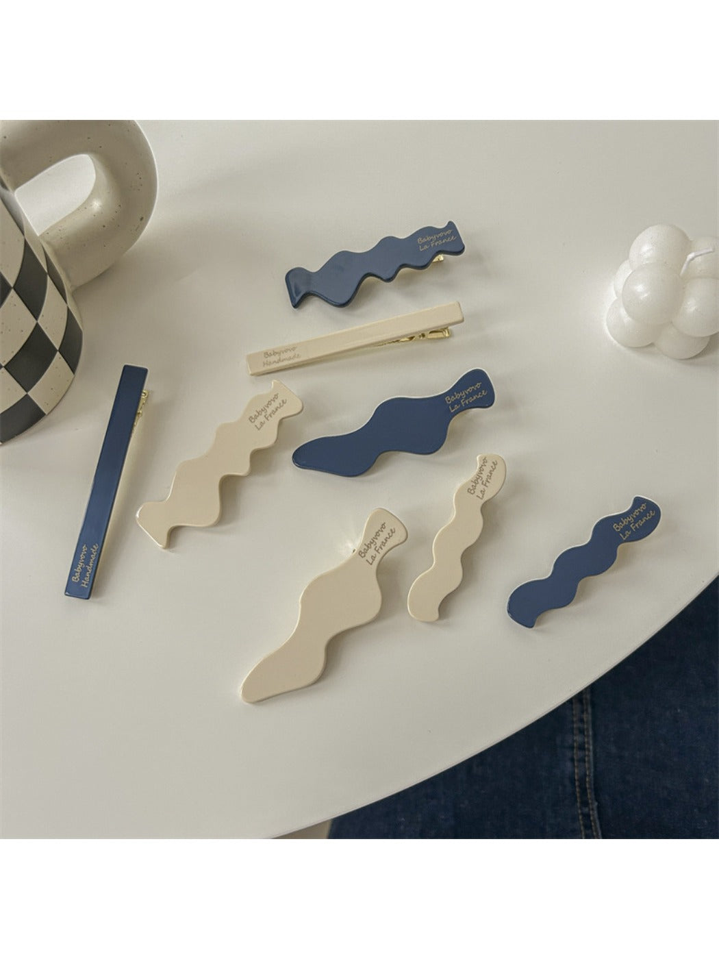 Side view of Beau hair clip highlighting the curved shape and blue floral details