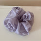 Scrunchie held in hand highlighting soft texture and gentle colors
