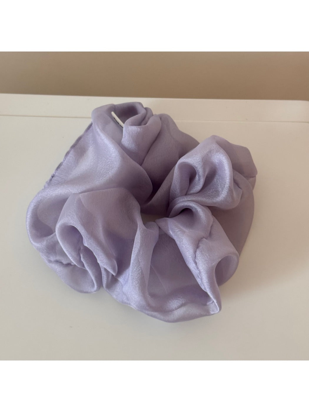 Scrunchie held in hand highlighting soft texture and gentle colors