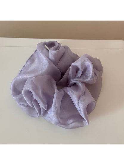 Scrunchie held in hand highlighting soft texture and gentle colors
