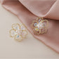 Small beaded flower earrings placed on a wooden surface with natural lighting