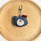Bear charm keychain on a colorful fabric background