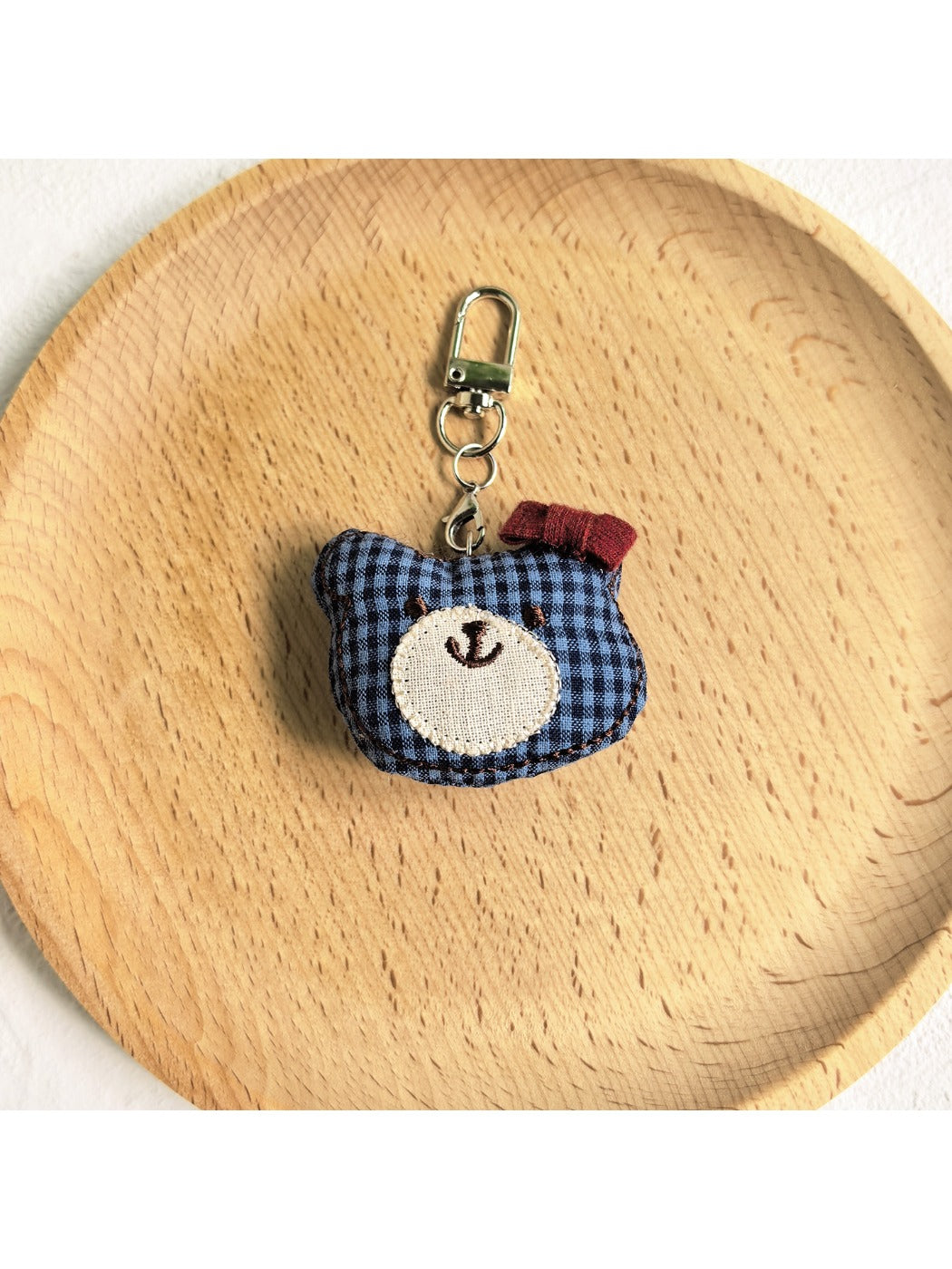Bear charm keychain on a colorful fabric background