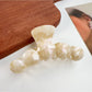 Beau hair claw clip in matte black finish displayed on wooden surface