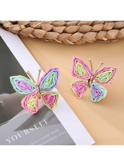 Earedge butterfly earrings hanging from a decorative branch