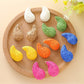 Close-up of Earedge raffia water drop shaped stud earrings on white background