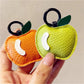 Close-up of red apple keychain showing smooth enamel surface and metal ring