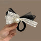 Classic black hair tie with a large satin bow embellished with small pearls