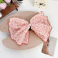 Beau Polka Dot Bow Claw Clip held in hand, showing size