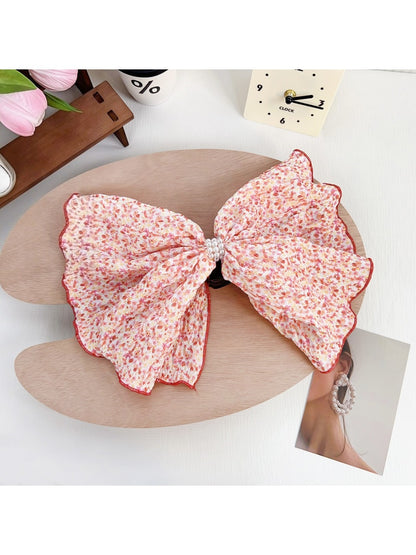 Beau Polka Dot Bow Claw Clip held in hand, showing size