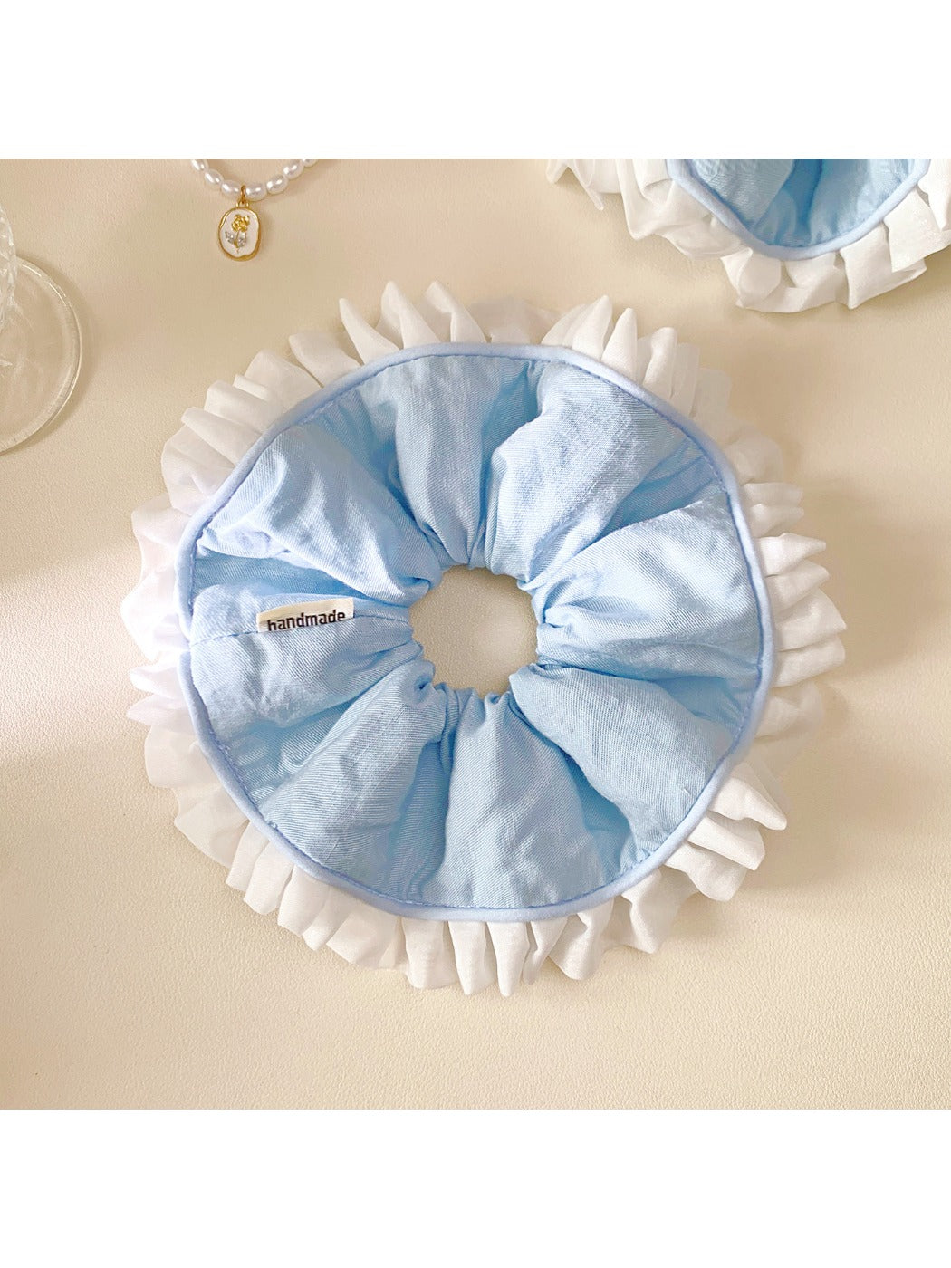 Close-up of white and blue ruffle scrunchie showing fabric texture