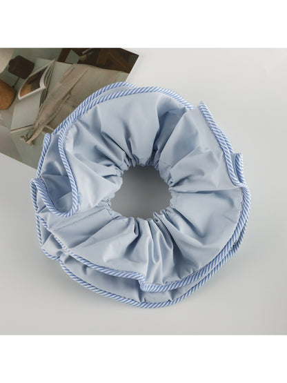Gifty scrunchie displayed with matching hair accessories on a wooden surface