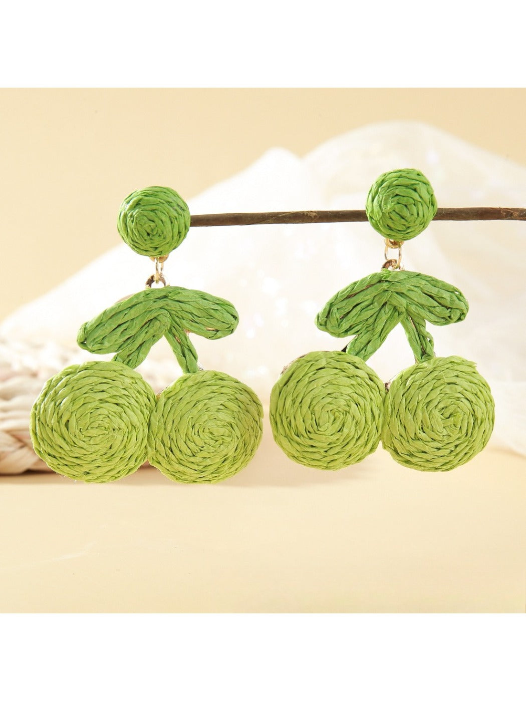 Earrings placed on a wooden surface highlighting natural raffia material