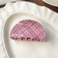 Beau pink plaid crescent shaped claw clip with metal spring visible