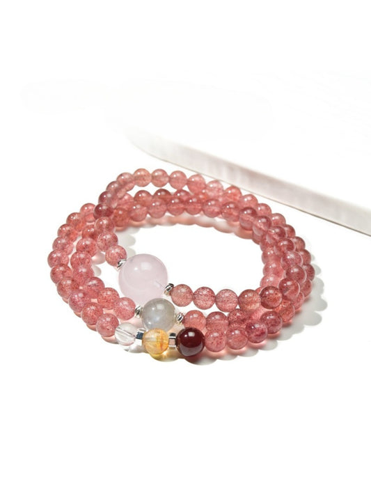 Lovra triple wrap bracelet with pink crystal beads and gold accents on a white background