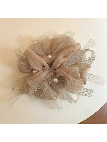 Close-up of Gifty elegant scrunchie with a large bow accent in soft fabric
