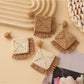 Close-up of Earedge geometric raffia square earrings on white background