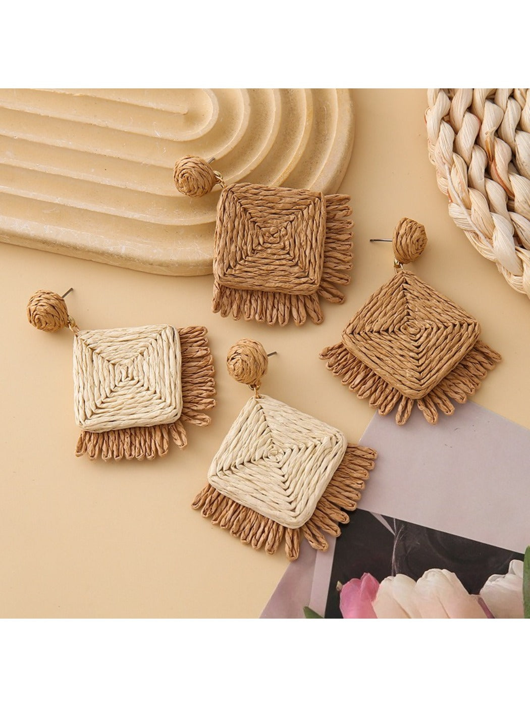Close-up of Earedge geometric raffia square earrings on white background
