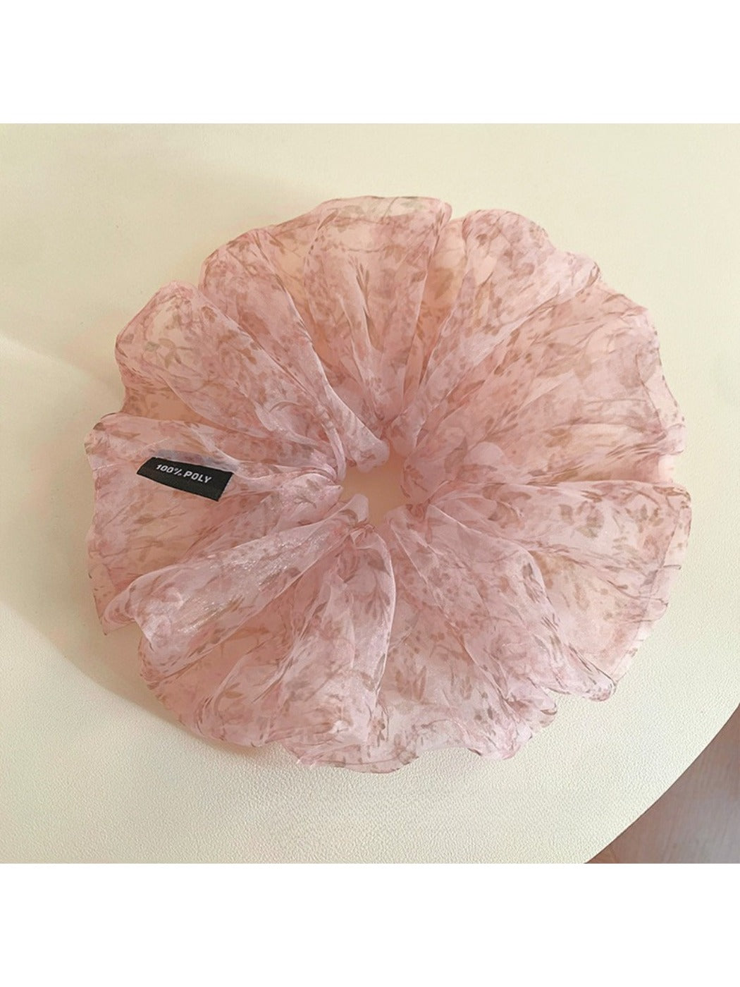Pink tulle scrunchie with tiny flowers wrapped around a ponytail