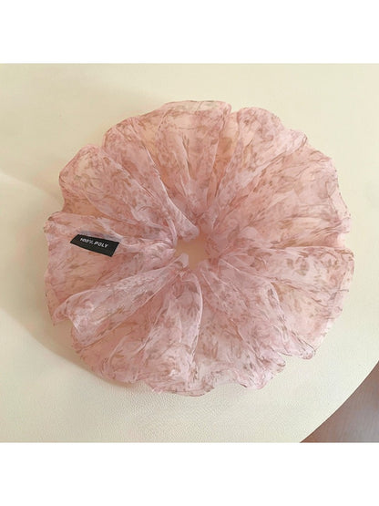 Pink tulle scrunchie with tiny flowers wrapped around a ponytail