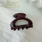 Beau vintage claw clip with openwork design resting on a wooden surface