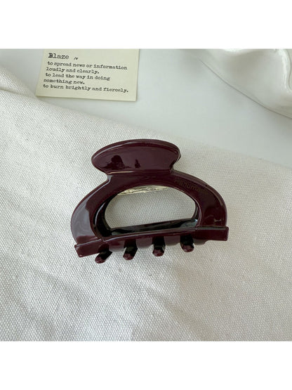 Beau vintage claw clip with openwork design resting on a wooden surface