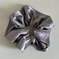Gifty satin scrunchie in soft pink color displayed against pastel background