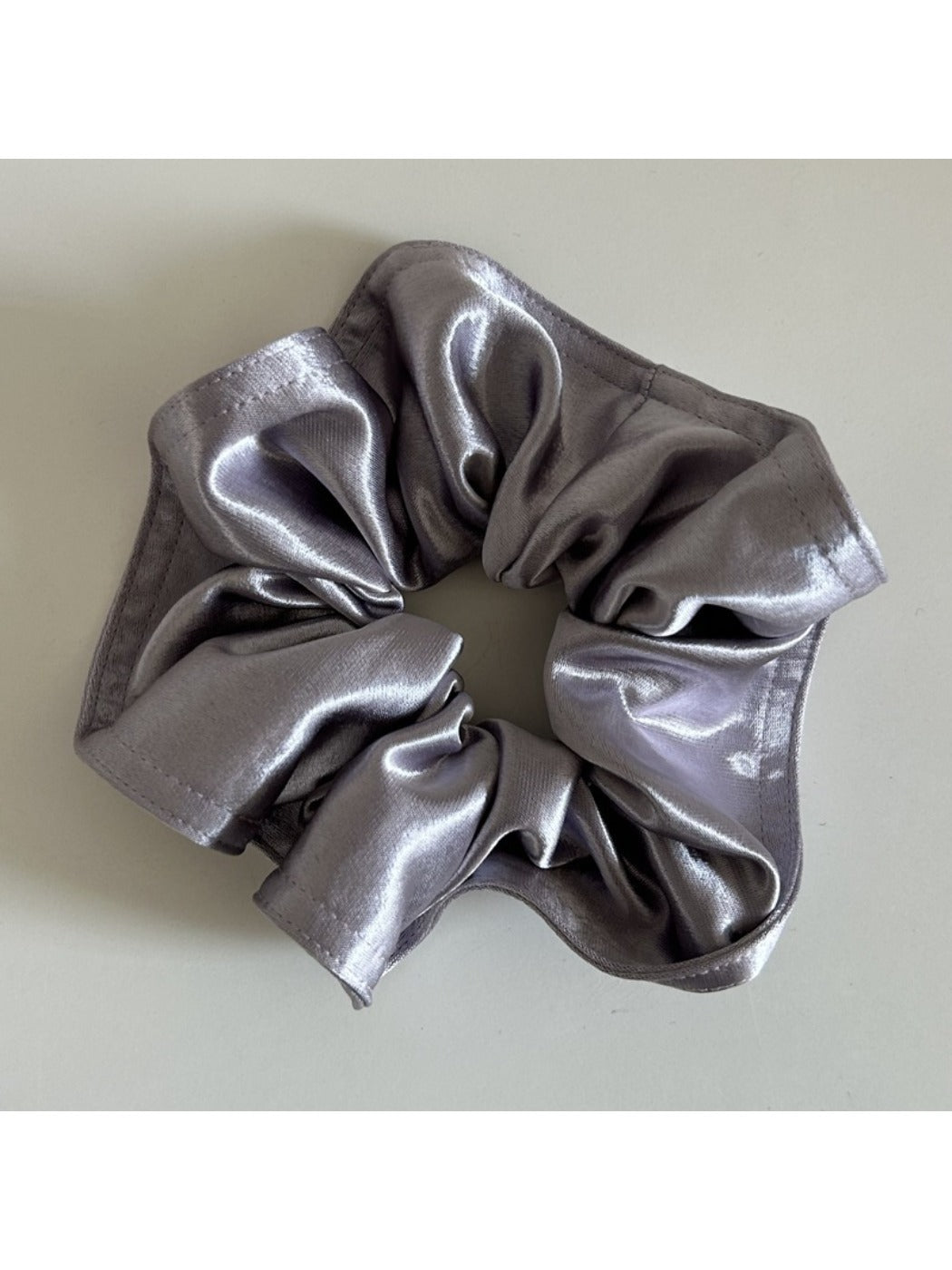 Gifty satin scrunchie in soft pink color displayed against pastel background