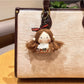 Hand holding the vintage girl charm keychain to show its size and portability