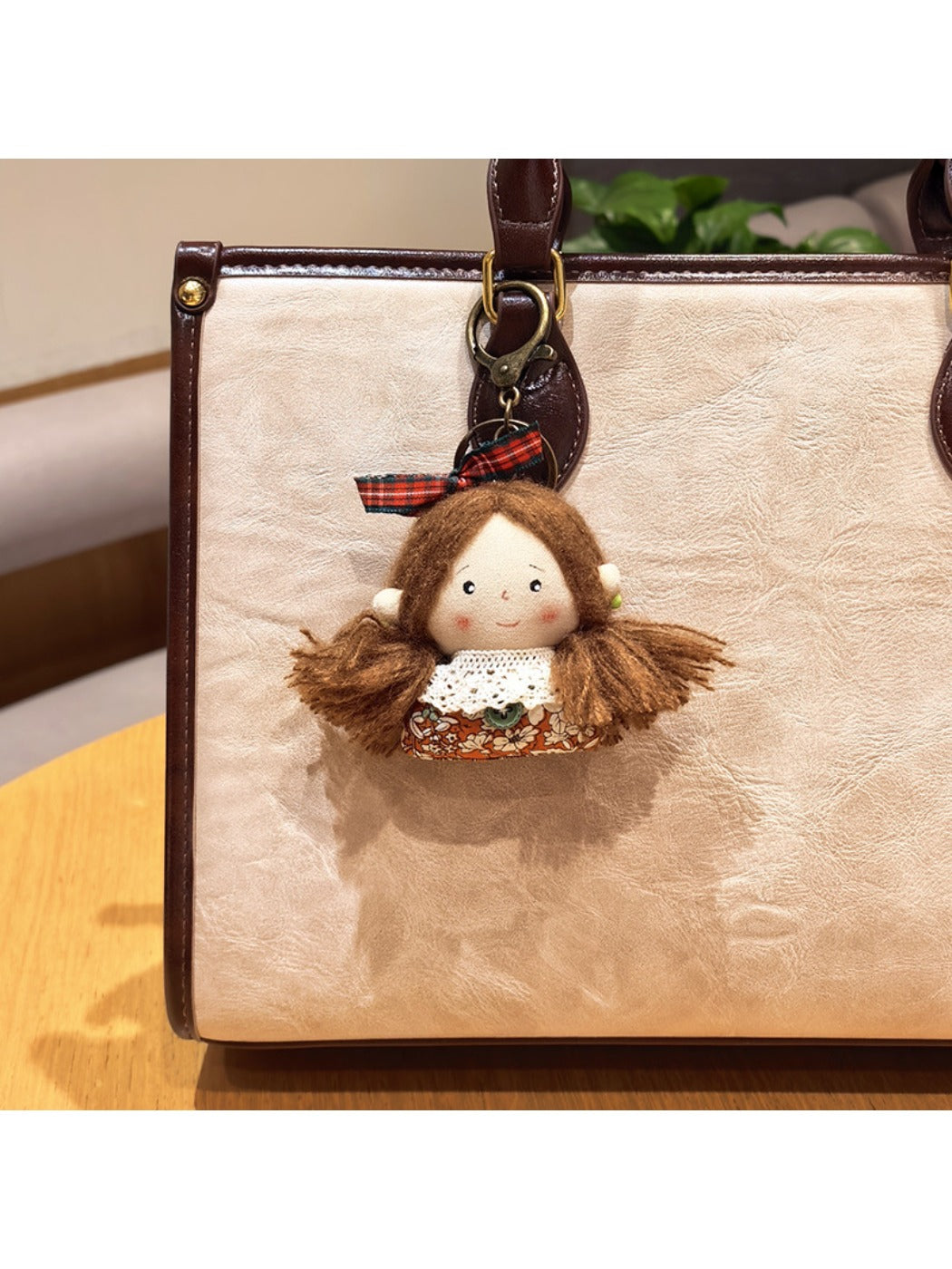 Hand holding the vintage girl charm keychain to show its size and portability