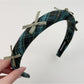 Gifty plaid bow headband placed next to matching plaid accessories