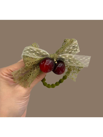 Green lace bow hair tie styled on a model's hair in a ponytail