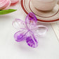 Beau colorful flower claw clip attached to hair demonstrating usage and hold