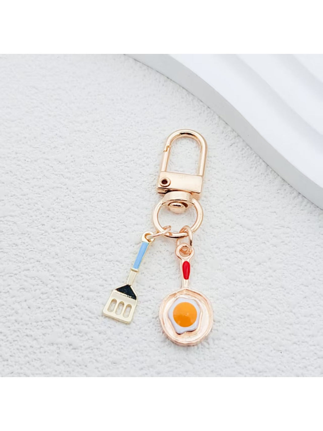 Spatula shaped keychain with wooden handle and metal blade detail