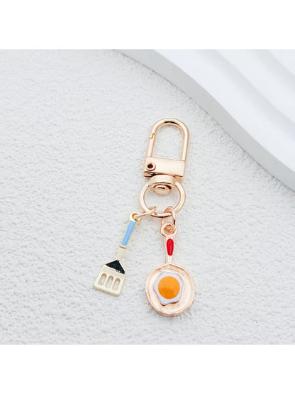Spatula shaped keychain with wooden handle and metal blade detail